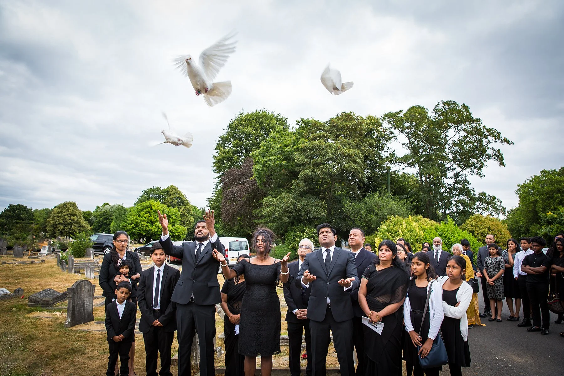White doves released at the graveside as family and mourners look on, photographed by funeral photographer Shaun Foulds