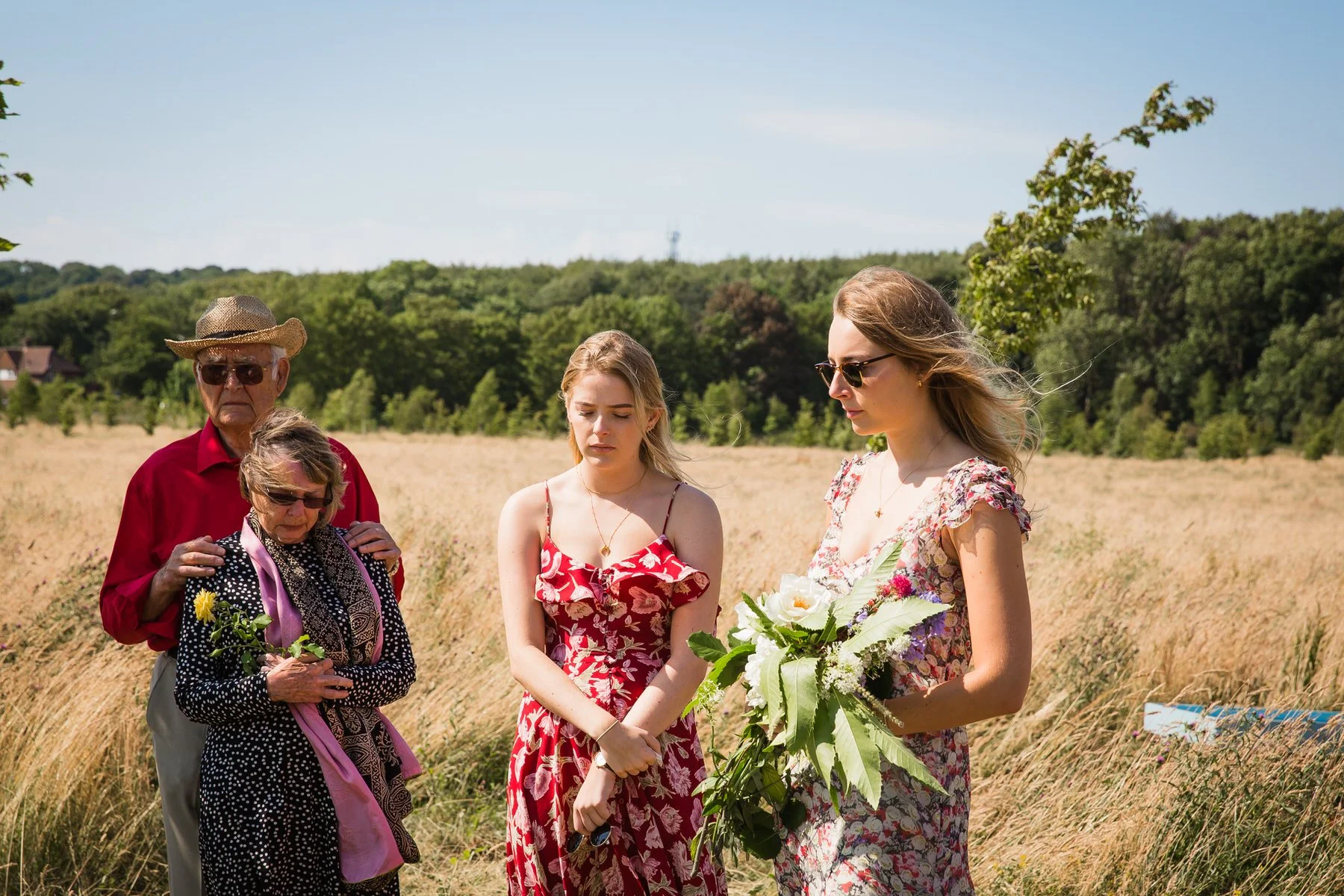Family and friends gathered around a natural burial grave at Clandon Wood Natural Burial Ground in Surrey.