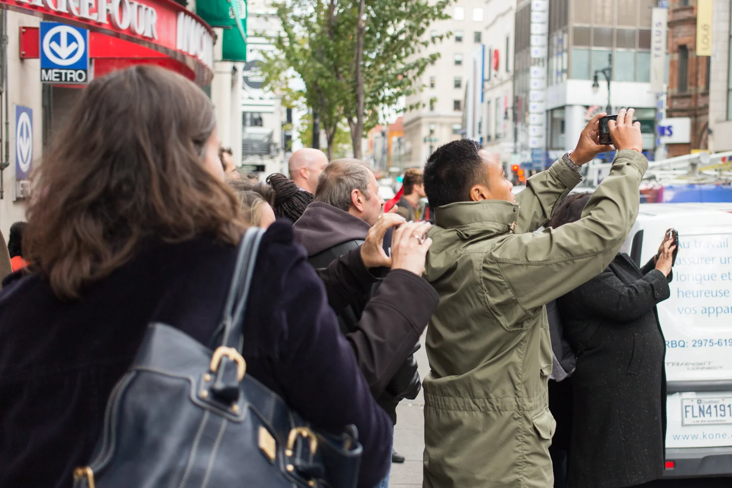 MONTREAL, QUEBEC – OCTOBER 19 2018 : The long lineup outside the Société Québécoise du Cannabis outlet on Ste-Catherine street on opening today attracted a crowd of viewers, photographing the historic event with their cell phones on October 17th, 2018 in Montreal, Quebec. (Photo by Matteo Gueli /Dawson College Photojournalism Class)