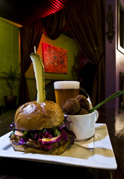 RON MEDVESCEK / ARIZONA DAILY STAR Haitian shredded pork sandwich and a side of hush puppies.