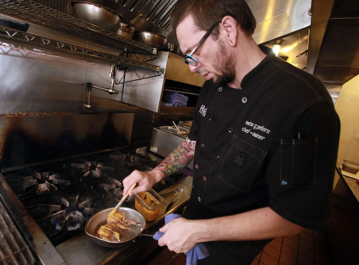 RON MEDVESCEK / ARIZONA DAILY STAR Chef Travis Peters works on his Alabama Quail dish at The Parish gastropub. "I want everything to have a reason Peter says.