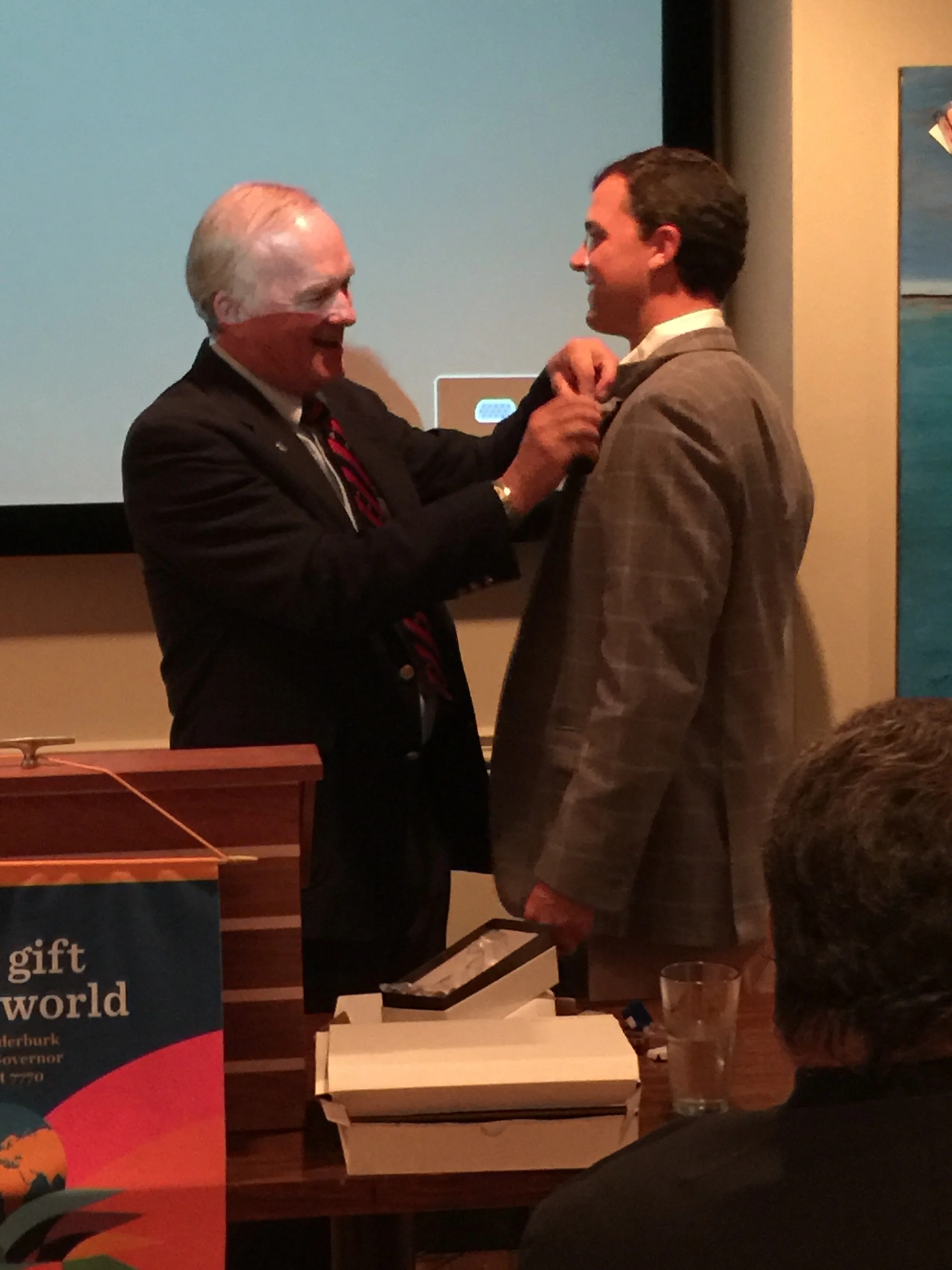President Charles Anderson gives Immediate Past President Rob Crawford his pin.