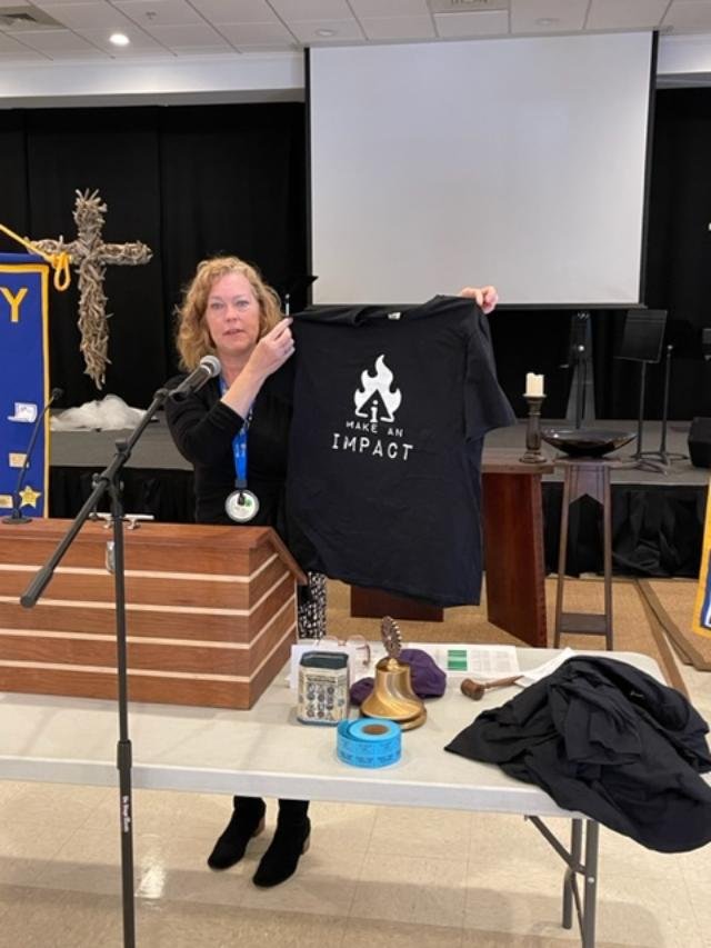 President Ulmer displays Impact Rotary Club t-shirt