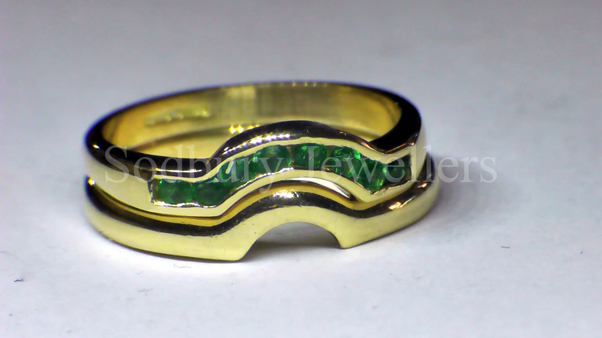 A shaped Emerald half eternity to fit customer's wedding ring. 