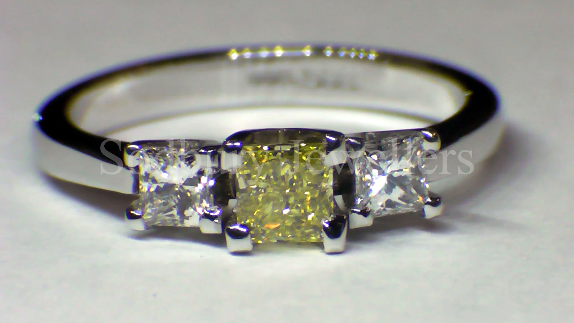A Princess cut Diamond ring, the centre Diamond is a Natural Yellow with a GIA certificate.