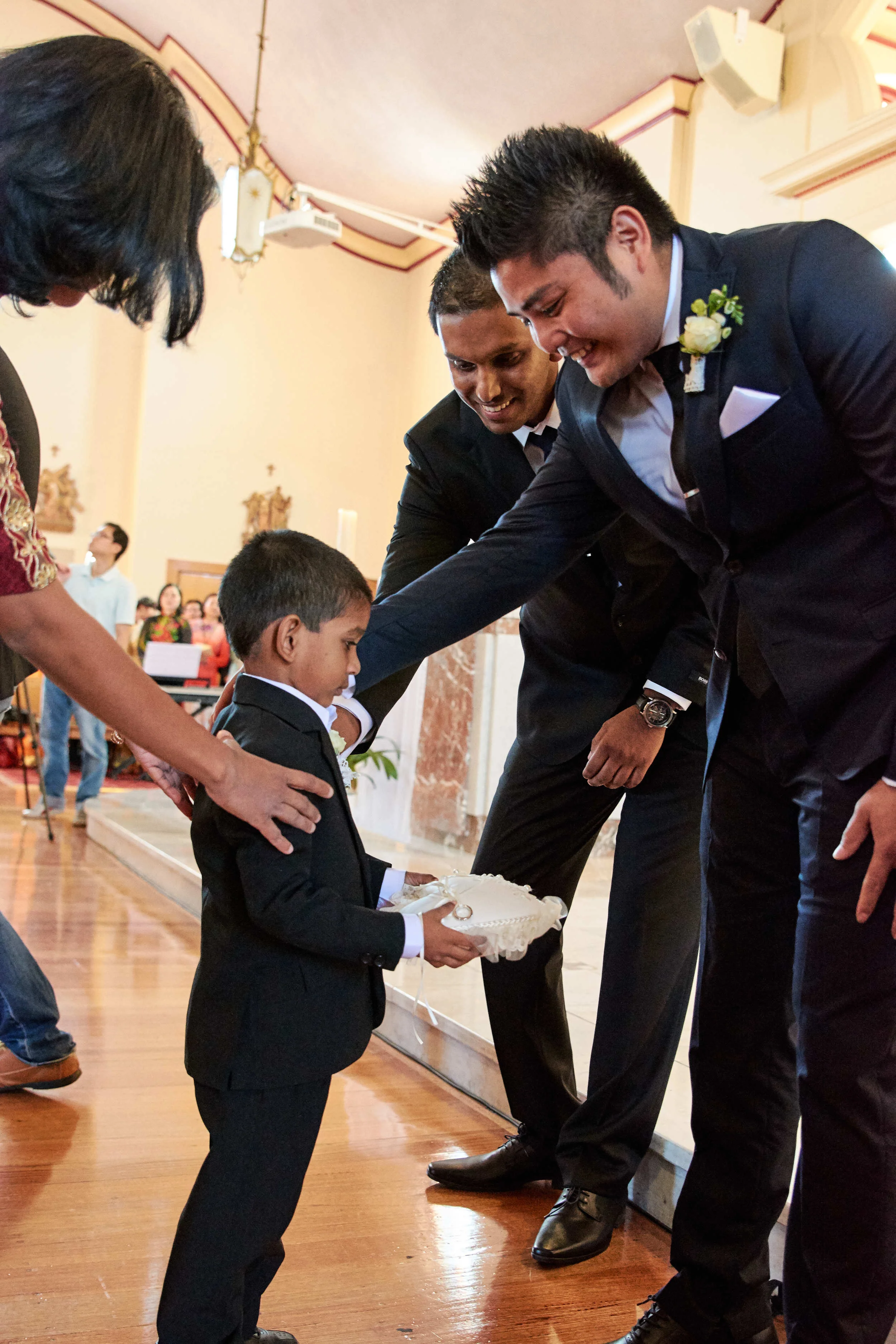 Ring bearer giving rings to the best man in Melbourne, Australia