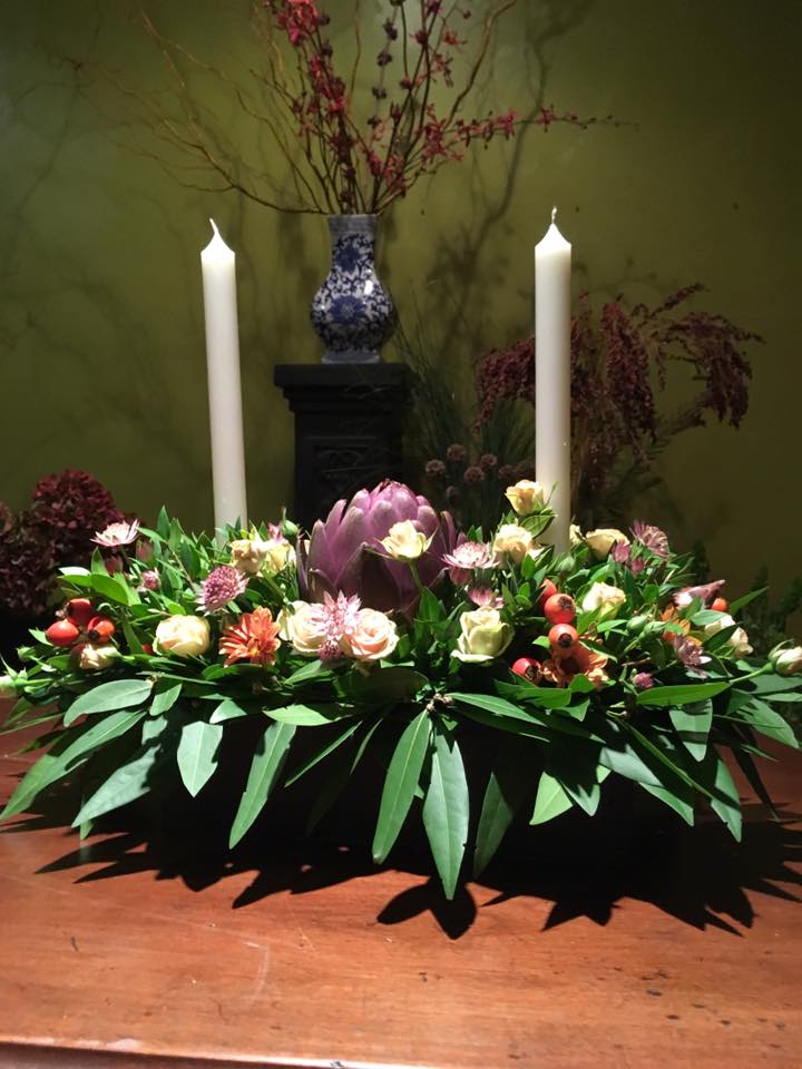 Thanksgiving centerpiece with flowers, leaves and pods.