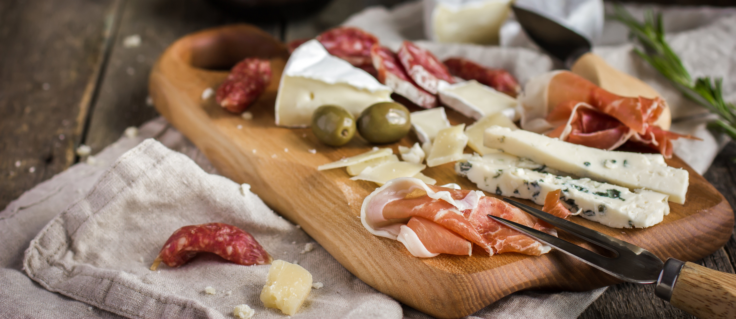 stock-photo-appetizers-various-types-of-cheese-salami-and-prosciutto-on-wooden-cutting-board-rustic-292123916 (1)_cropped.jpg