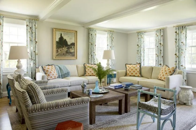 Pale-blue floral drapes add an element of the outdoors to the living room. The painting above the sofa came from homeowner Harrison Condon’s parents.