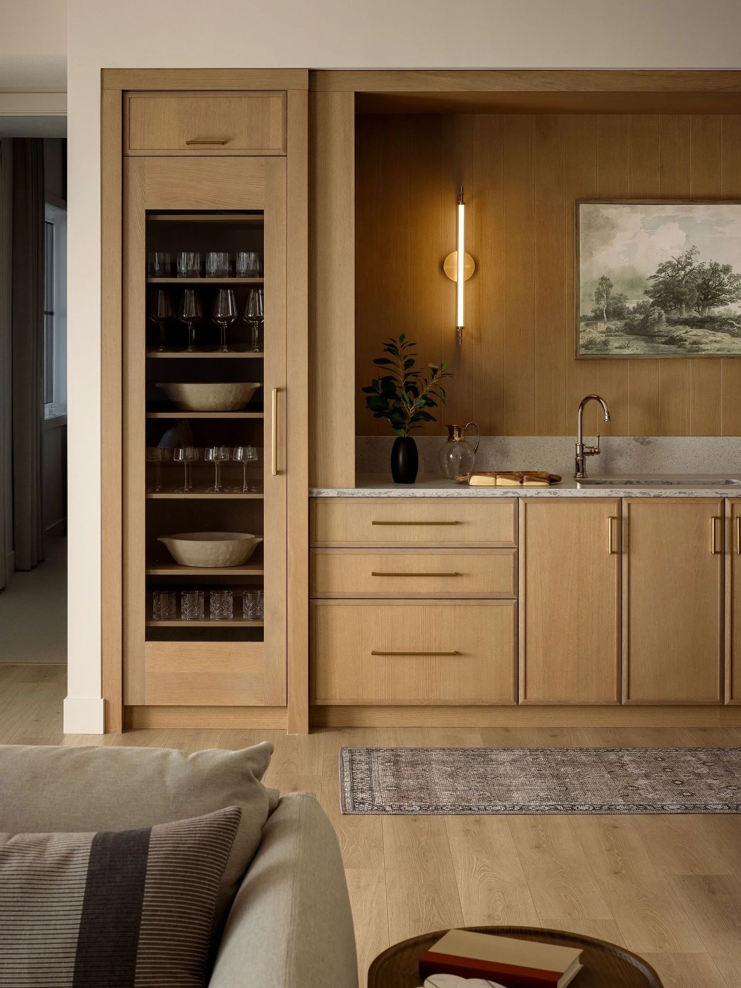 Lower levels deserve just as much attention!

This wet bar sits just off the media room, so it needed to function well and make a statement.

Warm wood panelling adds depth, integrated lighting, keeps it feeling elevated, and glass cabinetry brings b