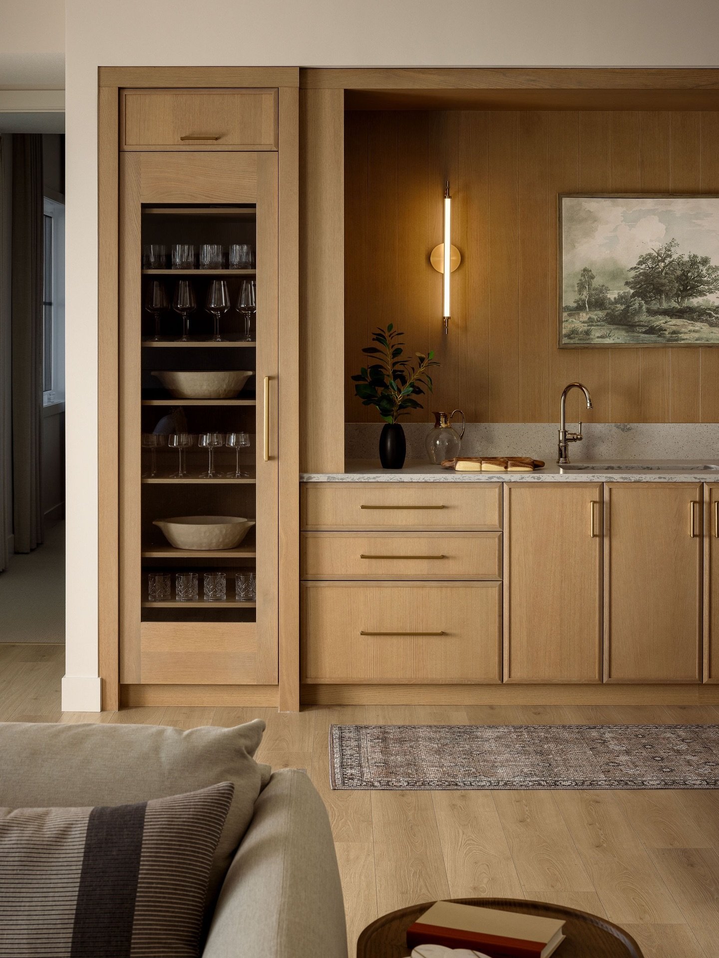 Lower levels deserve just as much attention!

This wet bar sits just off the media room, so it needed to function well and make a statement.

Warm wood panelling adds depth, integrated lighting, keeps it feeling elevated, and glass cabinetry brings b