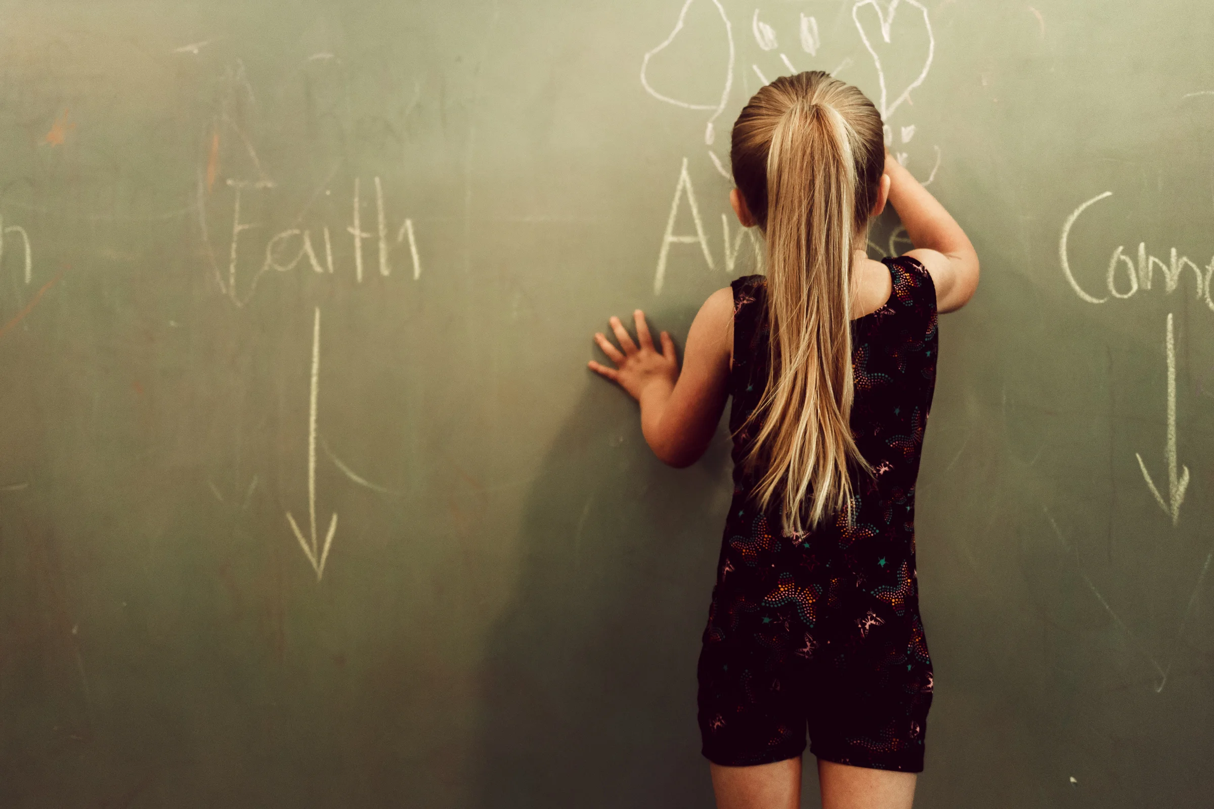 I teach a preschool gymnastics class in my home, and this morning was one of my gym days. I always have the kids draw a picture on the chalk wall over their name, in case they don't know what their name looks like and they need to remember where to sit when I tell them to go to their spot. :) I love this cute girl's long ponytail and hand on the wall.