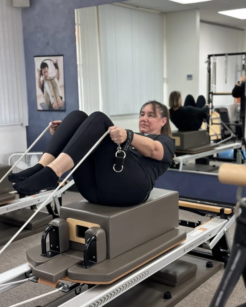 Client working with the straps on a reformer at Pure Power Pilates