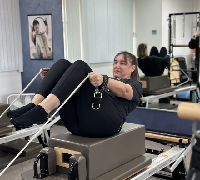 Client doing an advanced reformer exercise in Strength and Stability Pilates
