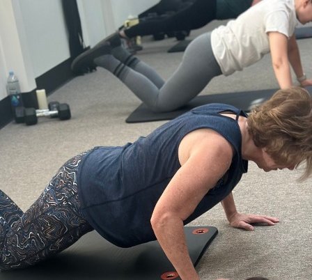 Clients doing push-ups during a Total Body Conditioning class