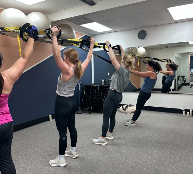 Clients using TRX suspension trainers in a Pure Strength class