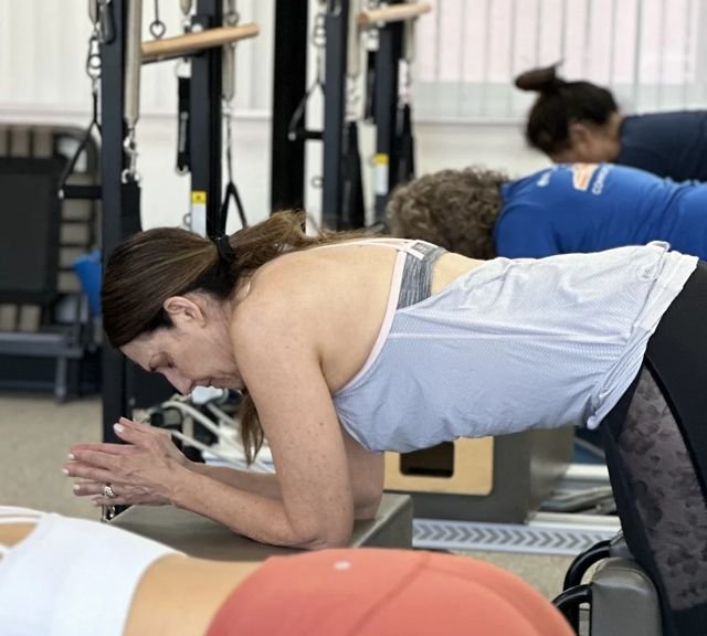 Clients doing kneeling exercises on reformers at Pure Power Pilates