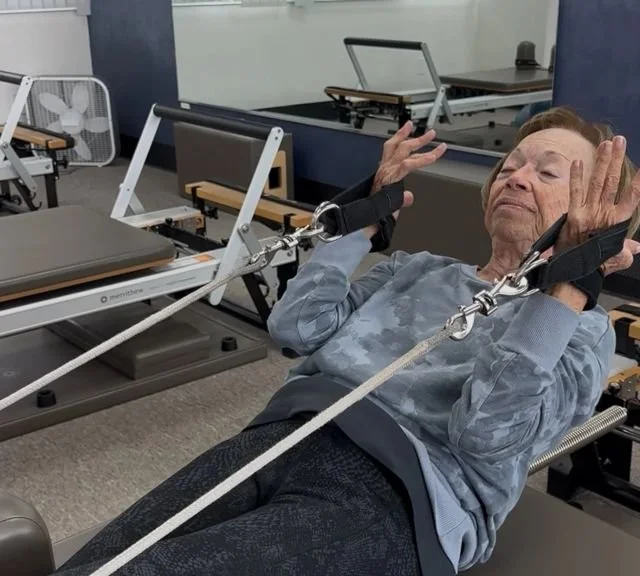 Client learning Pilates fundamentals on the reformer