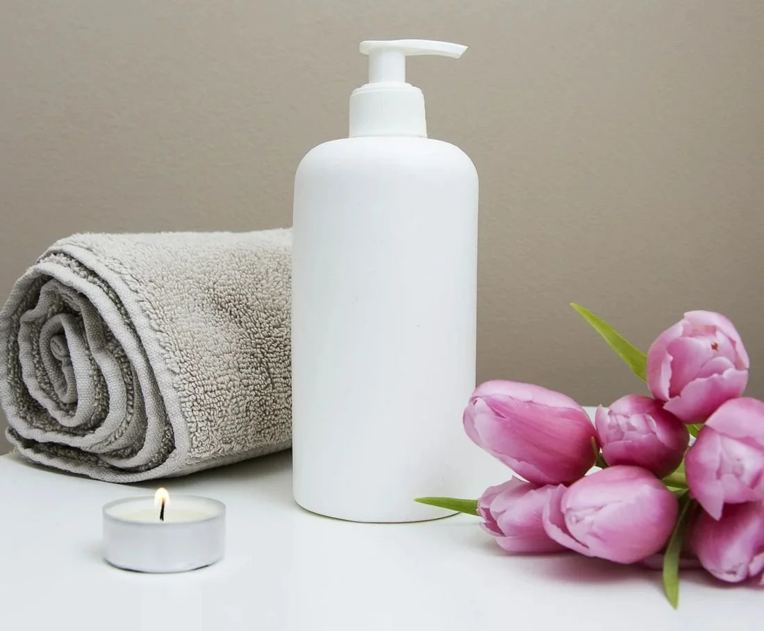 Massage oil, towel, and flowers ready for a massage session