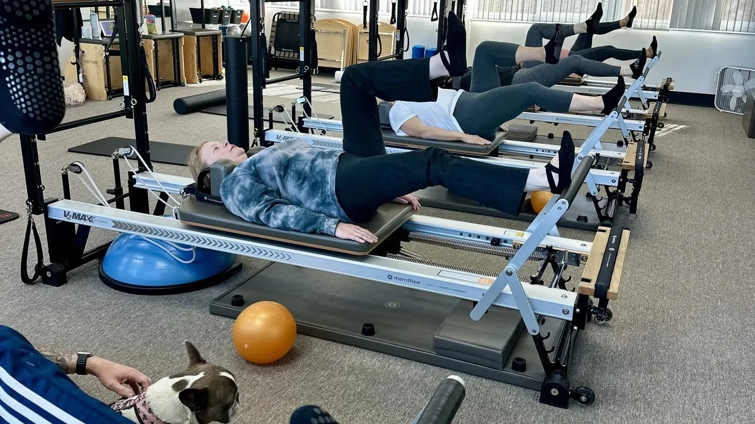 Clients on reformers during a group Reformer Pilates class at Pure Power Pilates