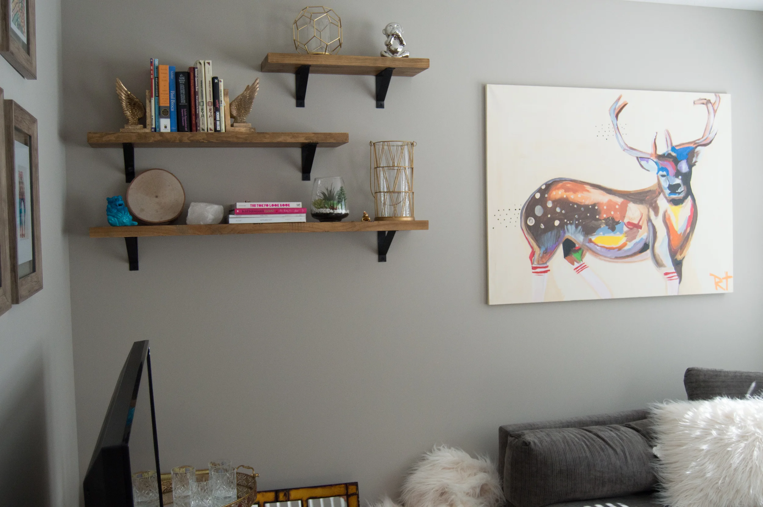 Notice the balance of space between the couch, the ceiling, the bookshelf and the art in this image. All items are spaced appropriately and nothing is too far apart. Give it a try!