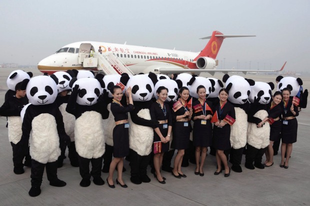 People in panda costumes pose with flight attendants in front of a Chengdu Airlines. Photo credit: AP.