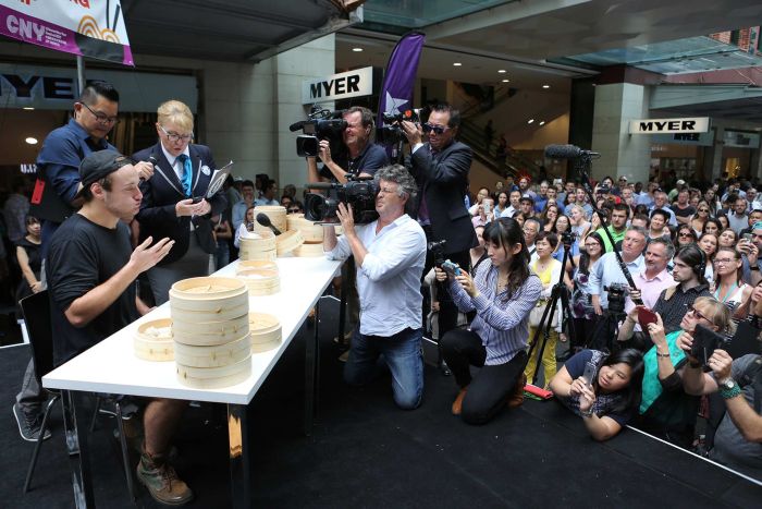 Isaac Harding going for gold at the Guinness World Record title for eating the most dumplings in two minutes at Pitt Street Mall, Sydney. ABC: Lisa Clarke