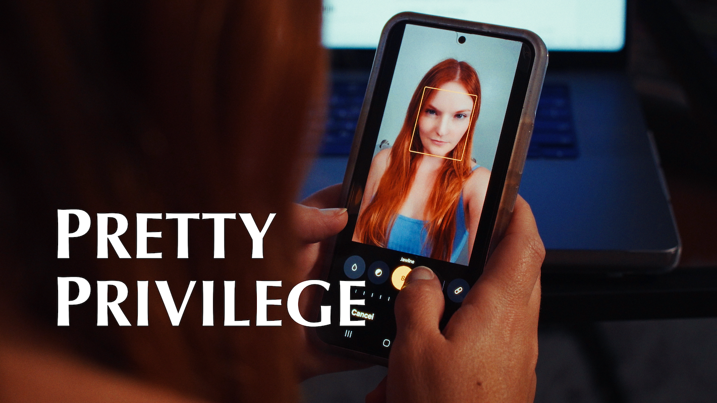 A person taking a selfie of a young woman with red hair on a smartphone. The woman is wearing a blue top and smiling slightly. The words 'PRETTY PRIVILEGE' are overlaid on the image.