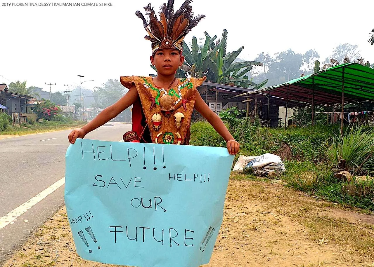 Sakolah Adat Arus Kualant (an indigenous-knowledge-based customary school) student striking in Dayak attire.