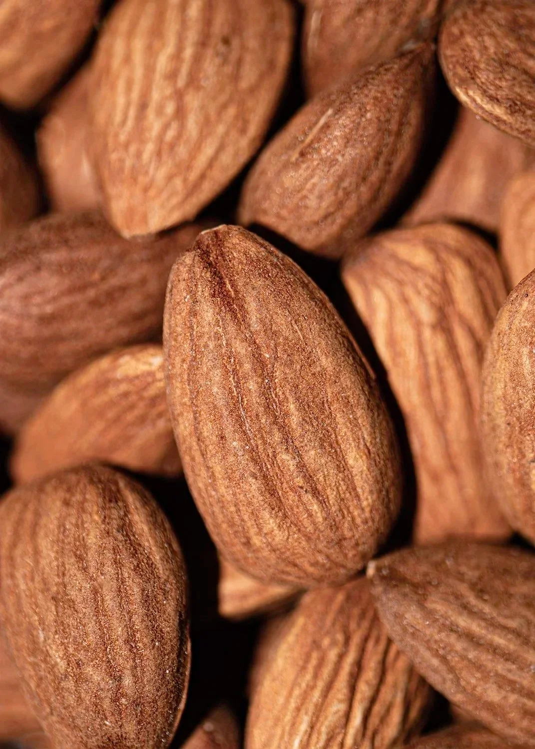 Close-up of whole almonds with textured brown shells.