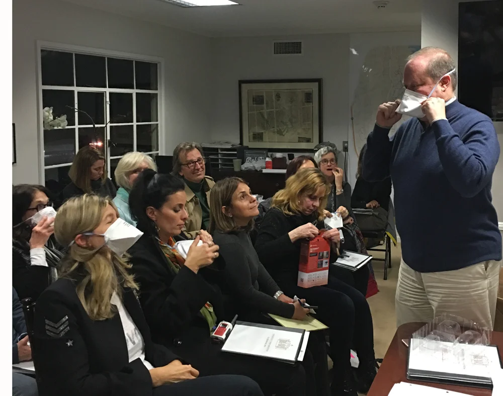 Dr. Goodman shows Neighborhood Team Captains how to properly don a N95 mask.