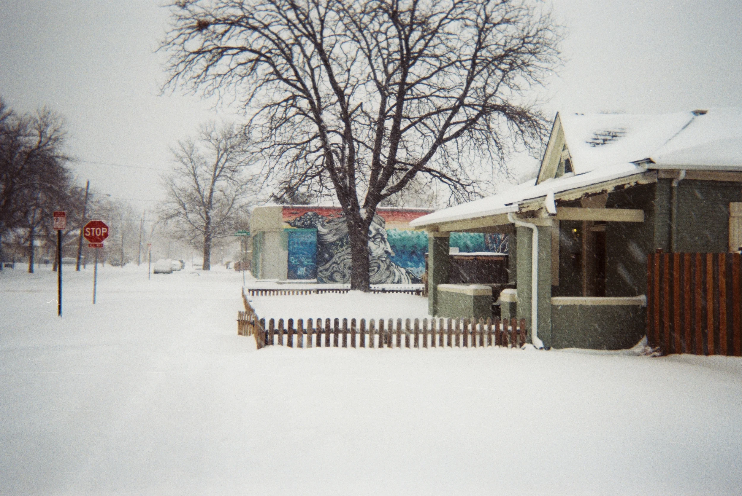 GOD LOOKS OUT OVER GALAPAGO As the house had all but cleared out before Thanksgiving, I decided to take a stroll out in what happened to be the biggest snow storm Denver had seen so far since my arrival. As I came back from Santa Fe Drive’s Art District, I noticed a man shoveling snow by himself along 3rd Ave. I also saw the mural of what I perceived to be God along Galapago, seemingly watching over this man, me, and all of Denver during this storm. A shiver came over me as I grabbed my camera- not from the cold, but from the realization that God was with me with every step I took. -Andrew Watson