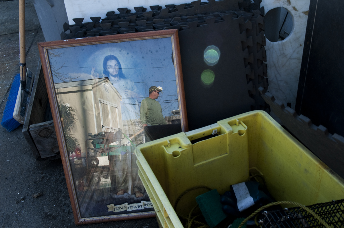  George, a friend of James Culleton and part-time fisherman, takes a break from cleaning and sorting through the contents of James’s home, which had been strewn across his yard to dry. All of James’s fishing work on land was based in sheds located in