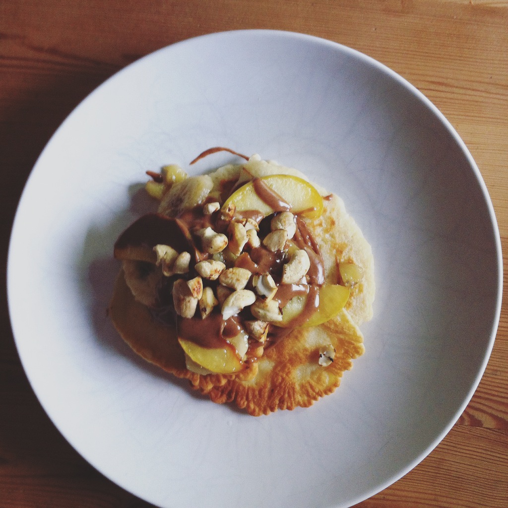 Dinkelvollkornpancakes mit Mandelmus und in Kokosöl gebratenen Apfel- und Bananenstücken und Cashewkernen