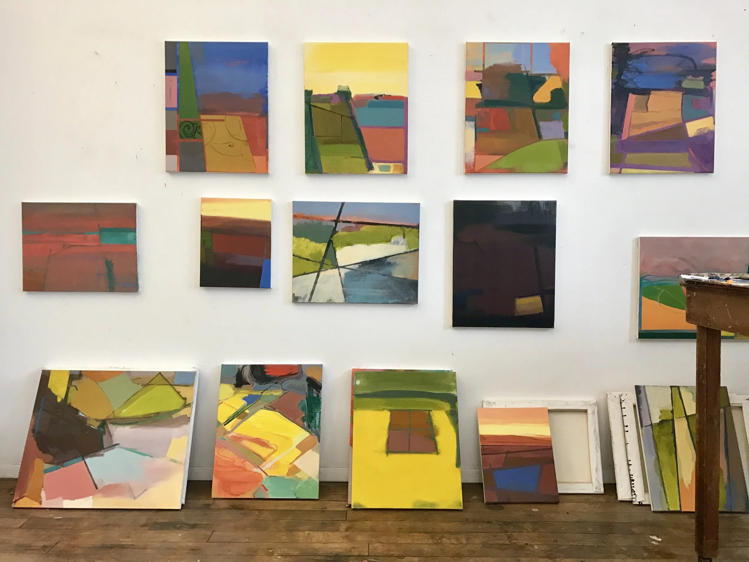 Paintings by Elizabeth Hazan hang and lean on the walls in her Brooklyn-based studio. Hazen uses old city maps as influence for her paintings. 