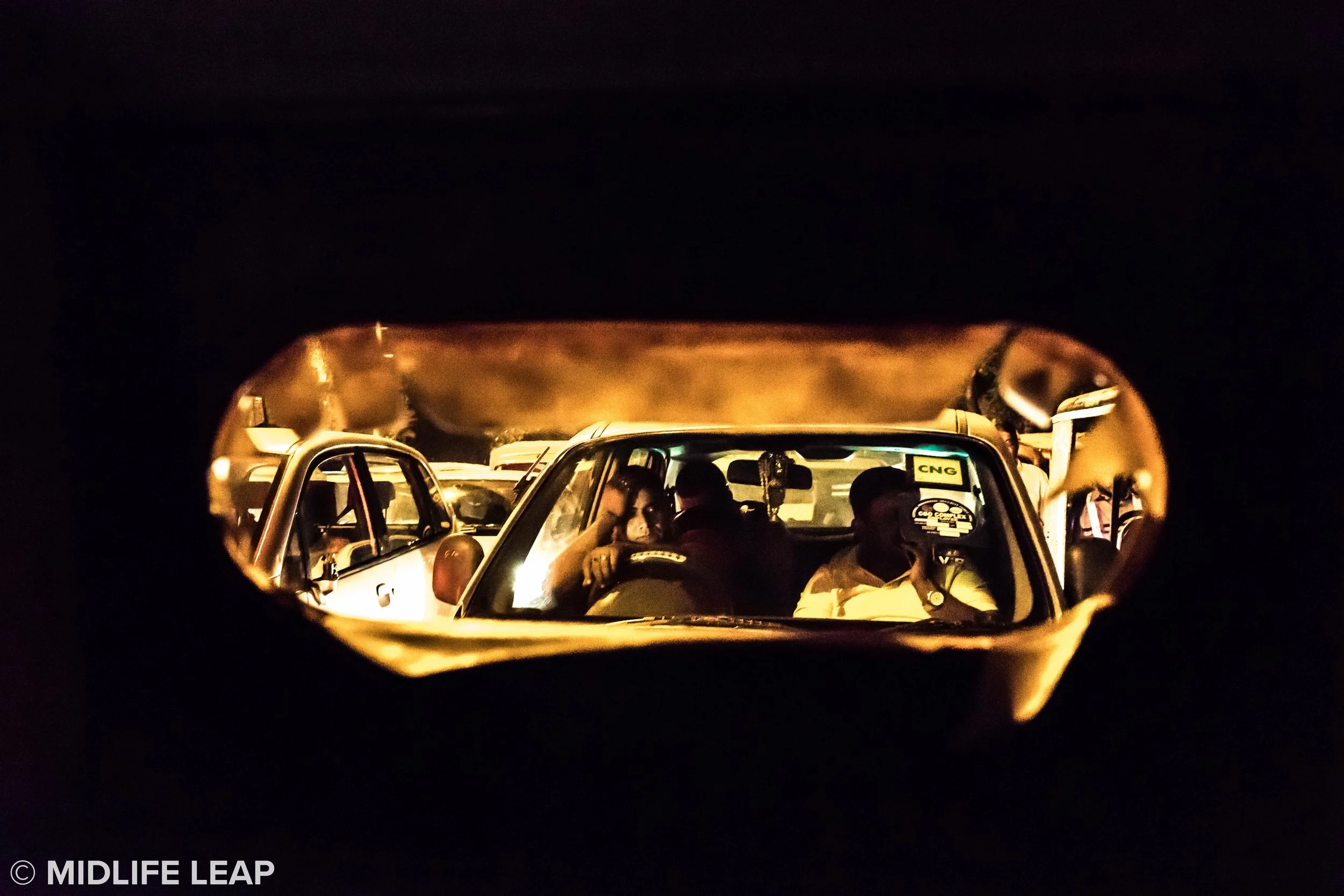 Traffic jam through a broken screen of a rickshaw