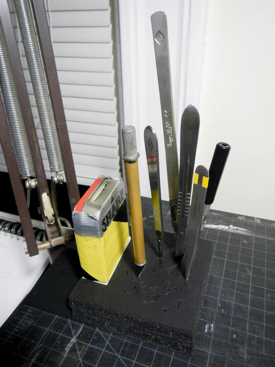 I built this knife station so it is held down by the clamp on my task lamp. (Click photo to enlarge.)