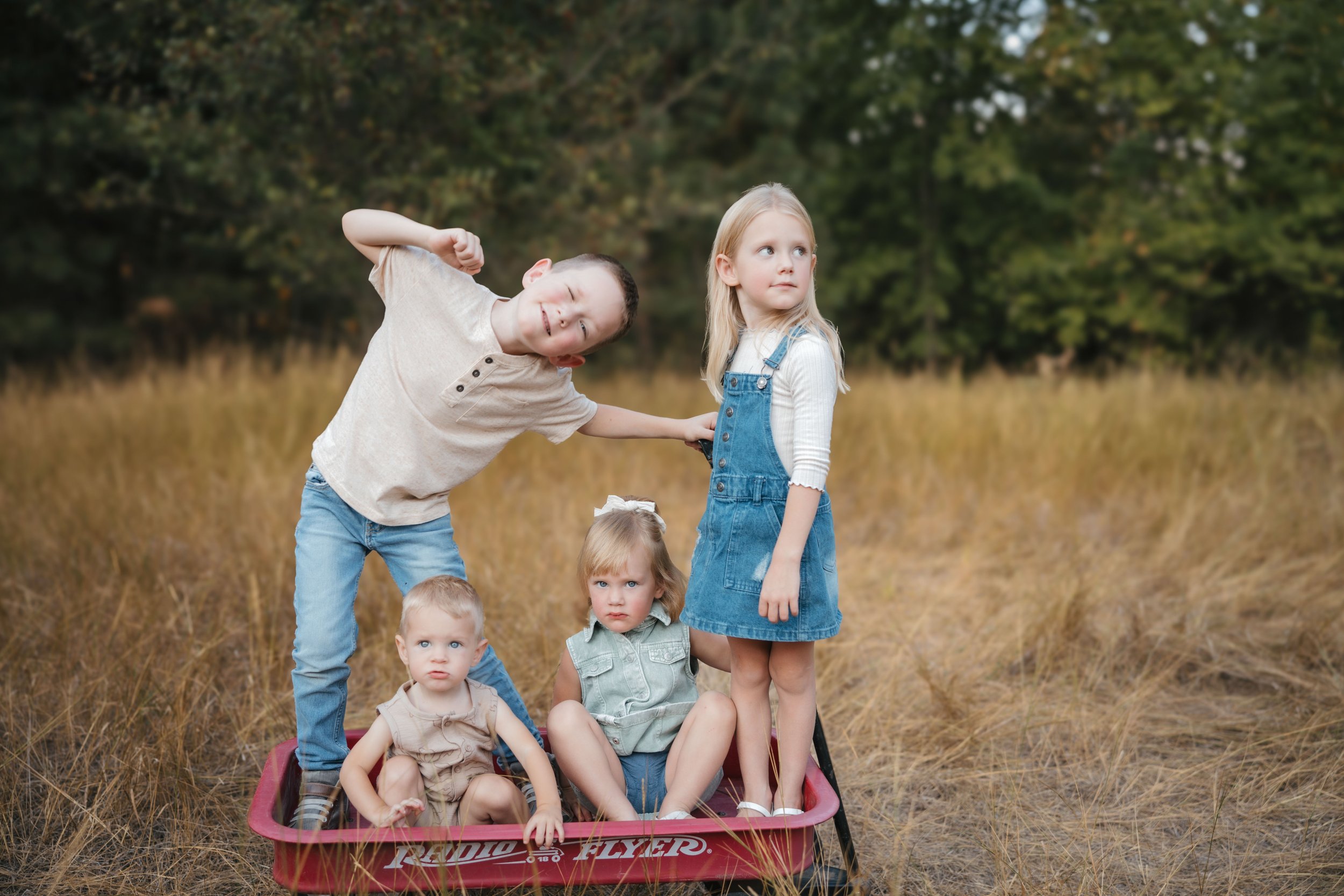 kids in a red flyer wagon in field coeur d alene
