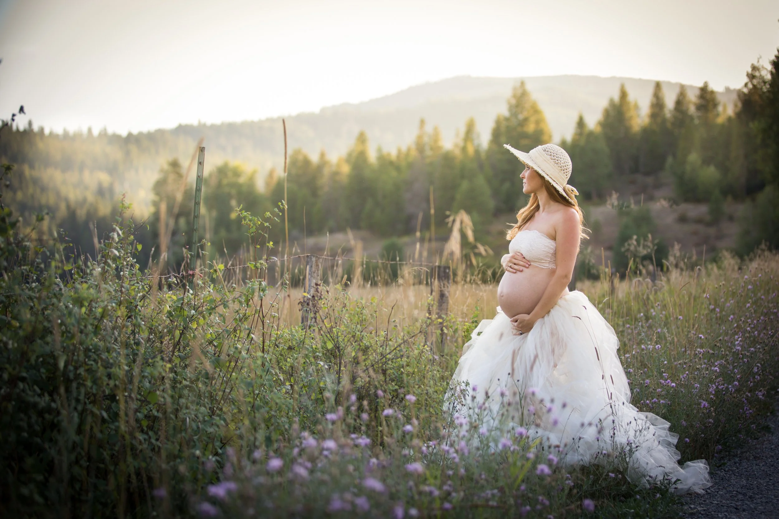 A golden-hour maternity portrait surrounded by wildflowers, celebrating the calm beauty of pregnancy.