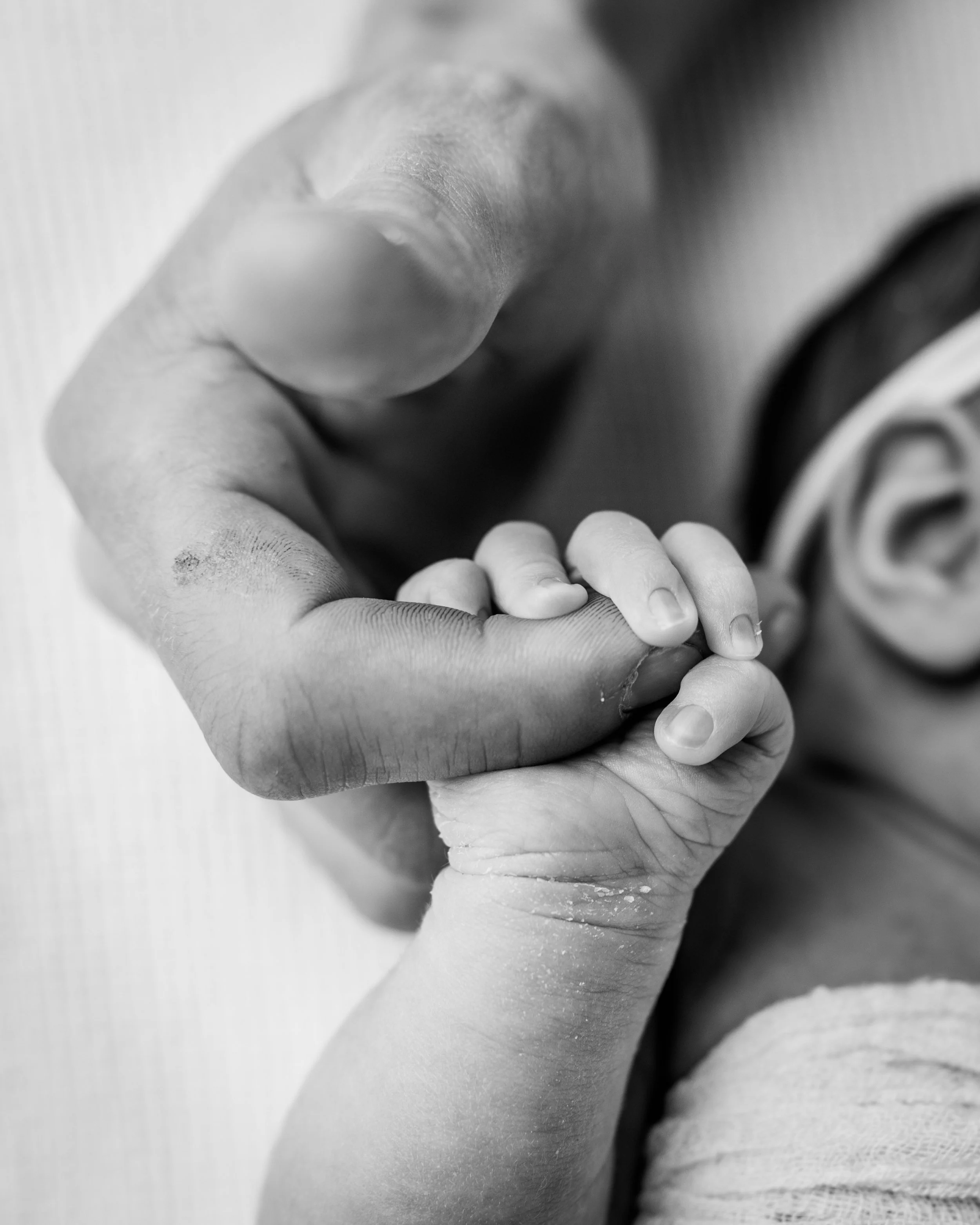father holding newborns tiny brand new hands