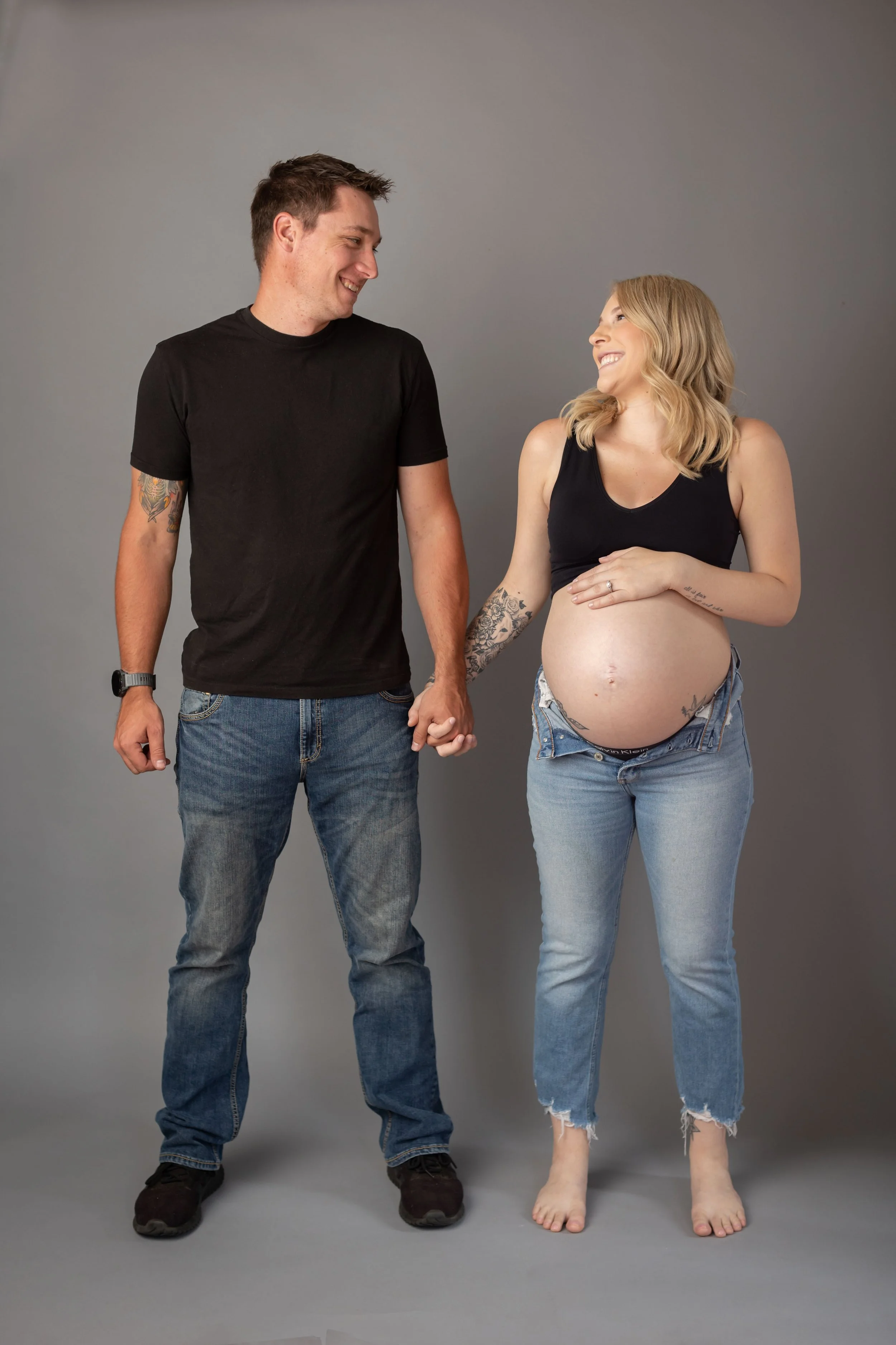 A simple and modern studio maternity portrait capturing connection, excitement, and anticipation.