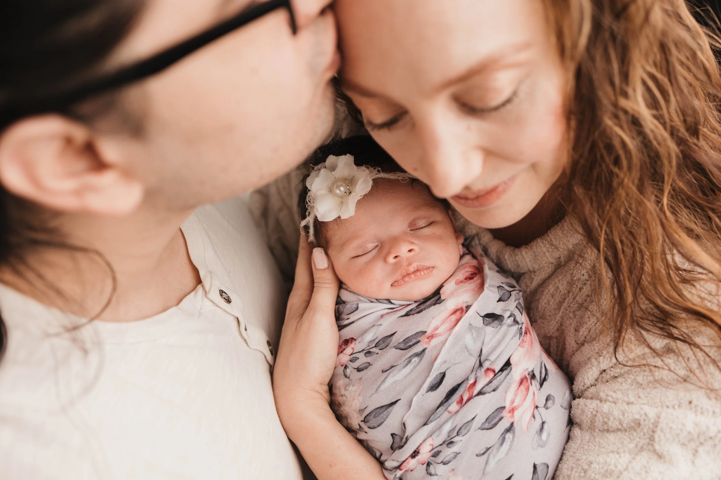 Parents cuddling newborn baby in cozy lifestyle newborn session