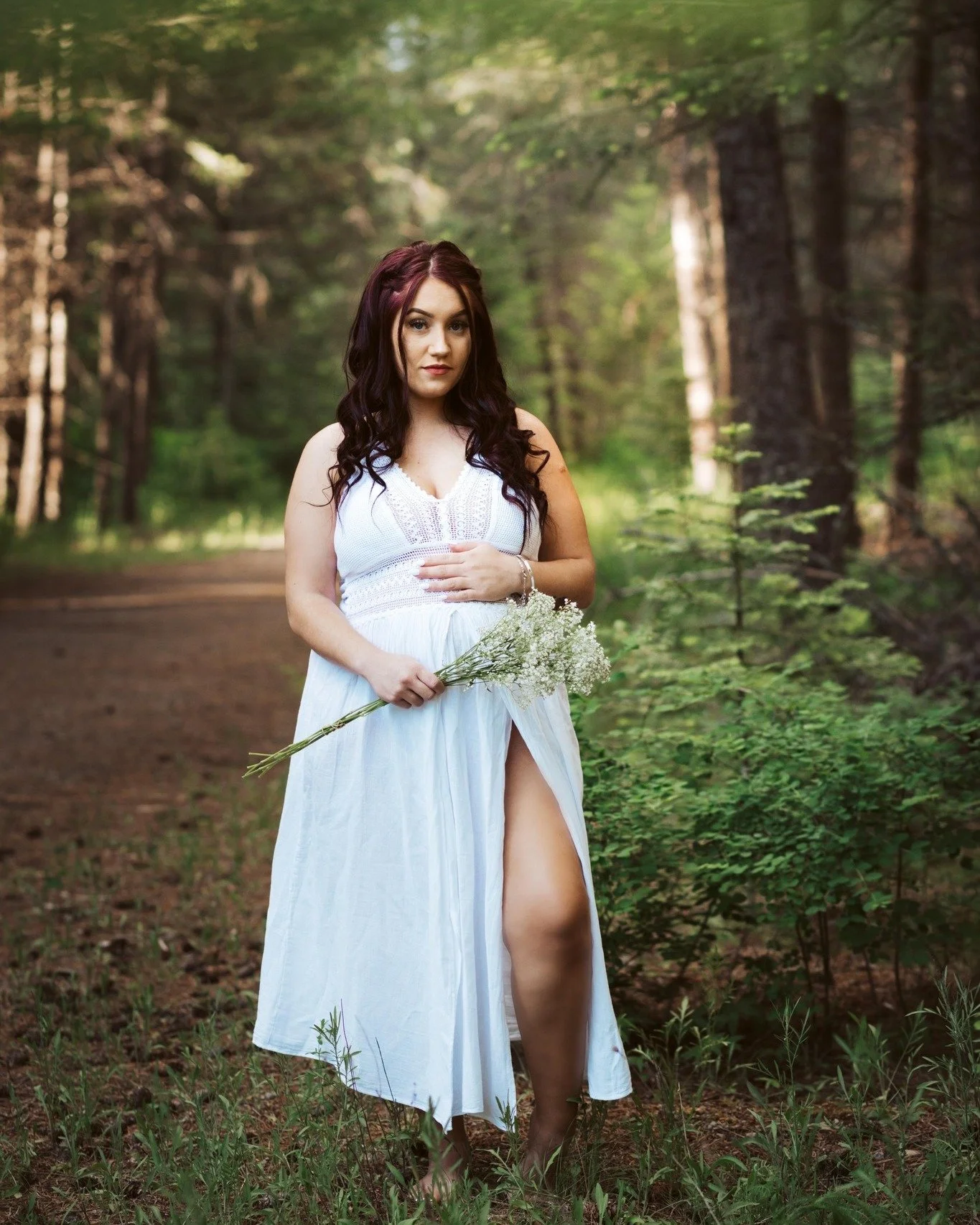 A dreamy woodland maternity portrait highlighting the peaceful connection between motherhood and nature.