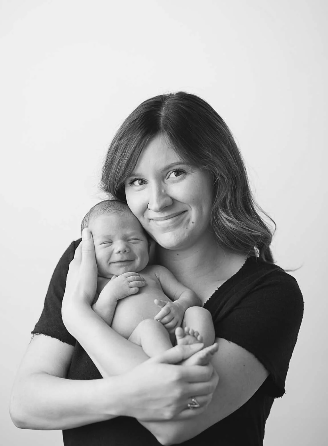 mother and baby smiling in studio black and white