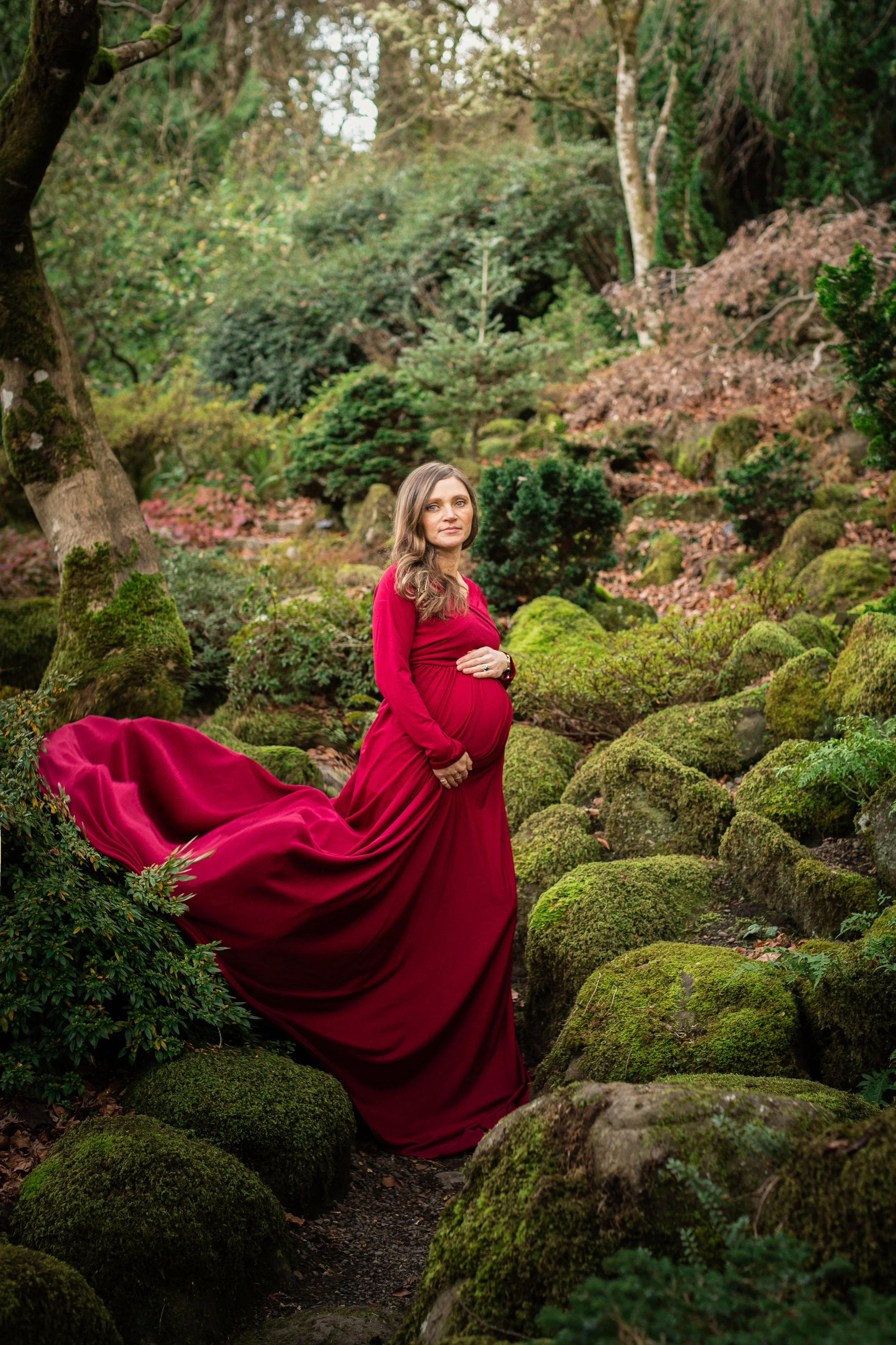 A powerful maternity portrait in red dress capturing the quiet bond between a mother and her child before baby arrives.