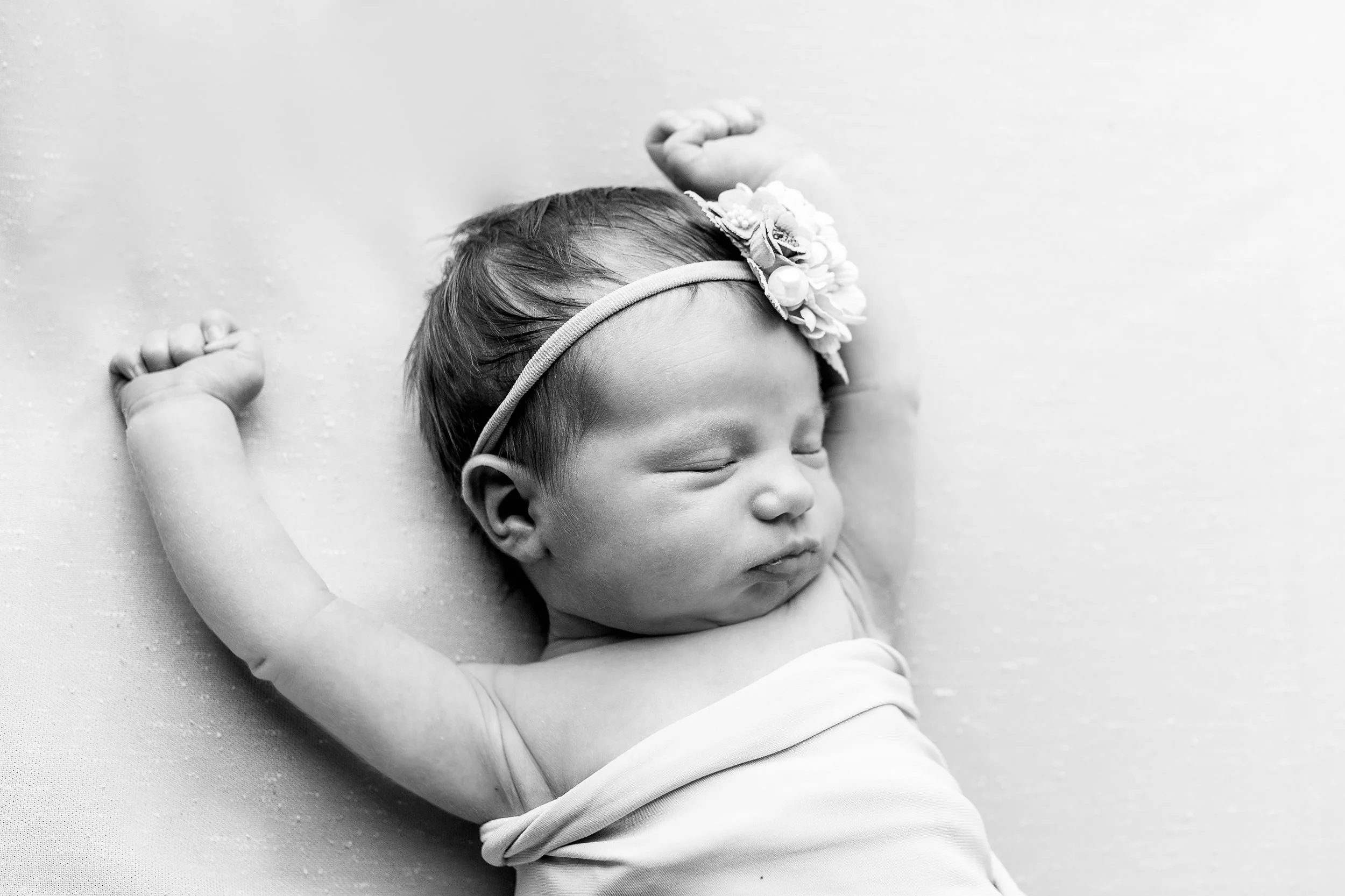 Close-up newborn baby sleeping wrapped in neutral swaddle