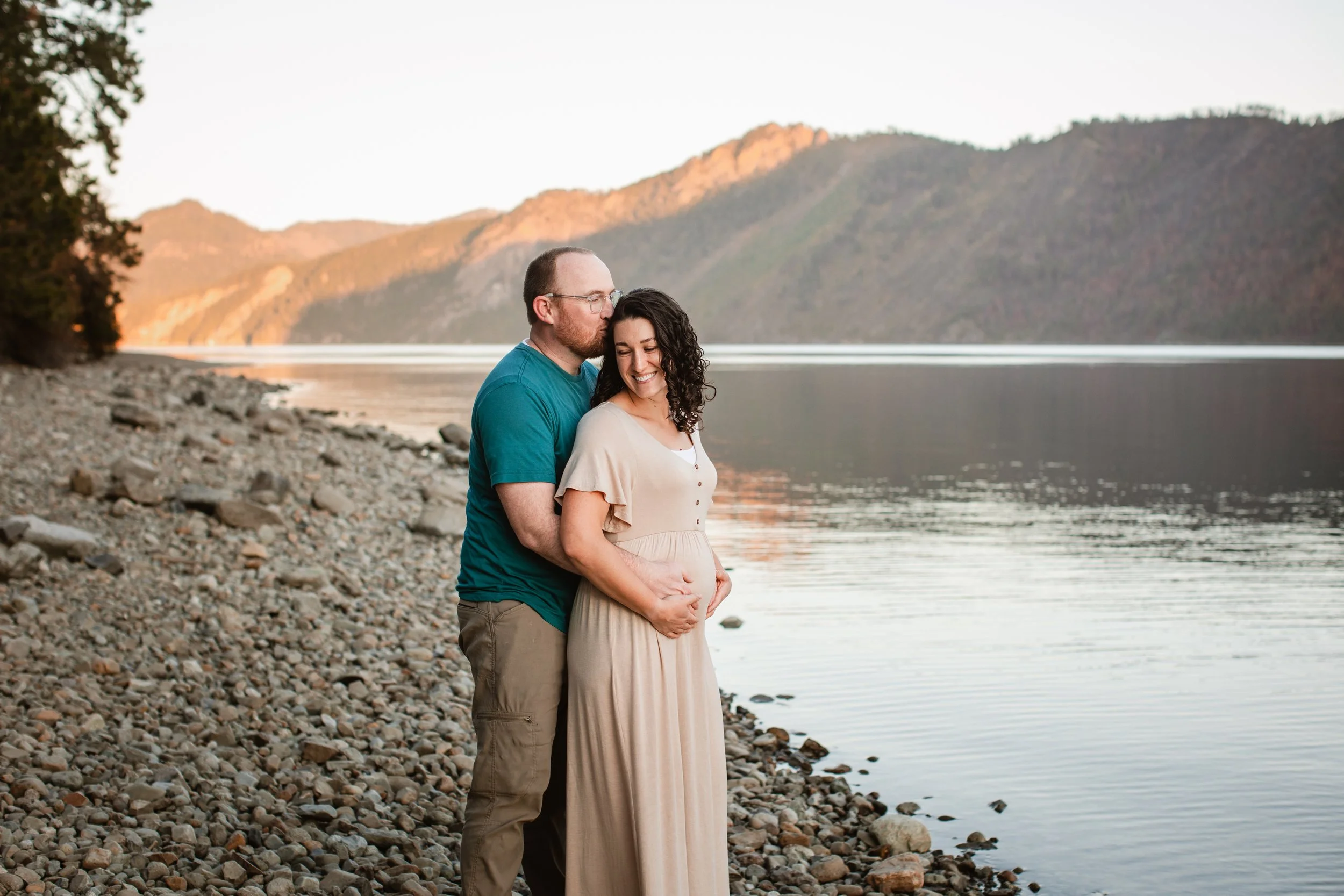 Emotional maternity portrait of couple holding belly in North Idaho mountains