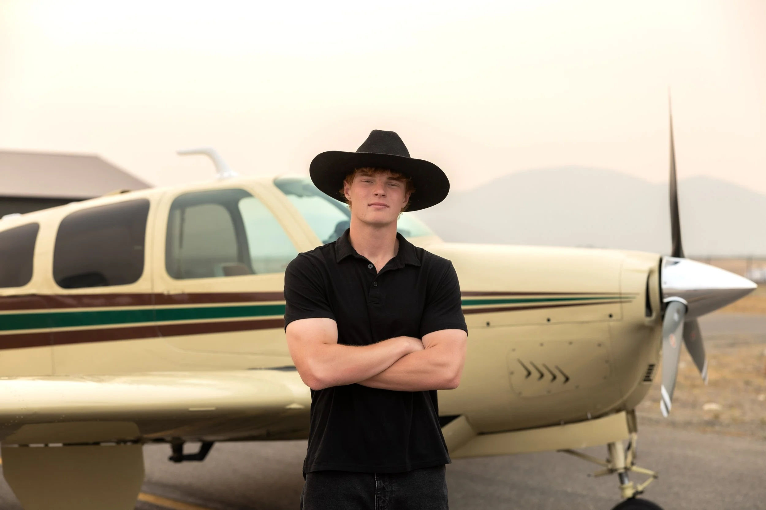 Natural light senior session with soft tones and confident styling. North Idaho senior photographer capturing authentic personality.