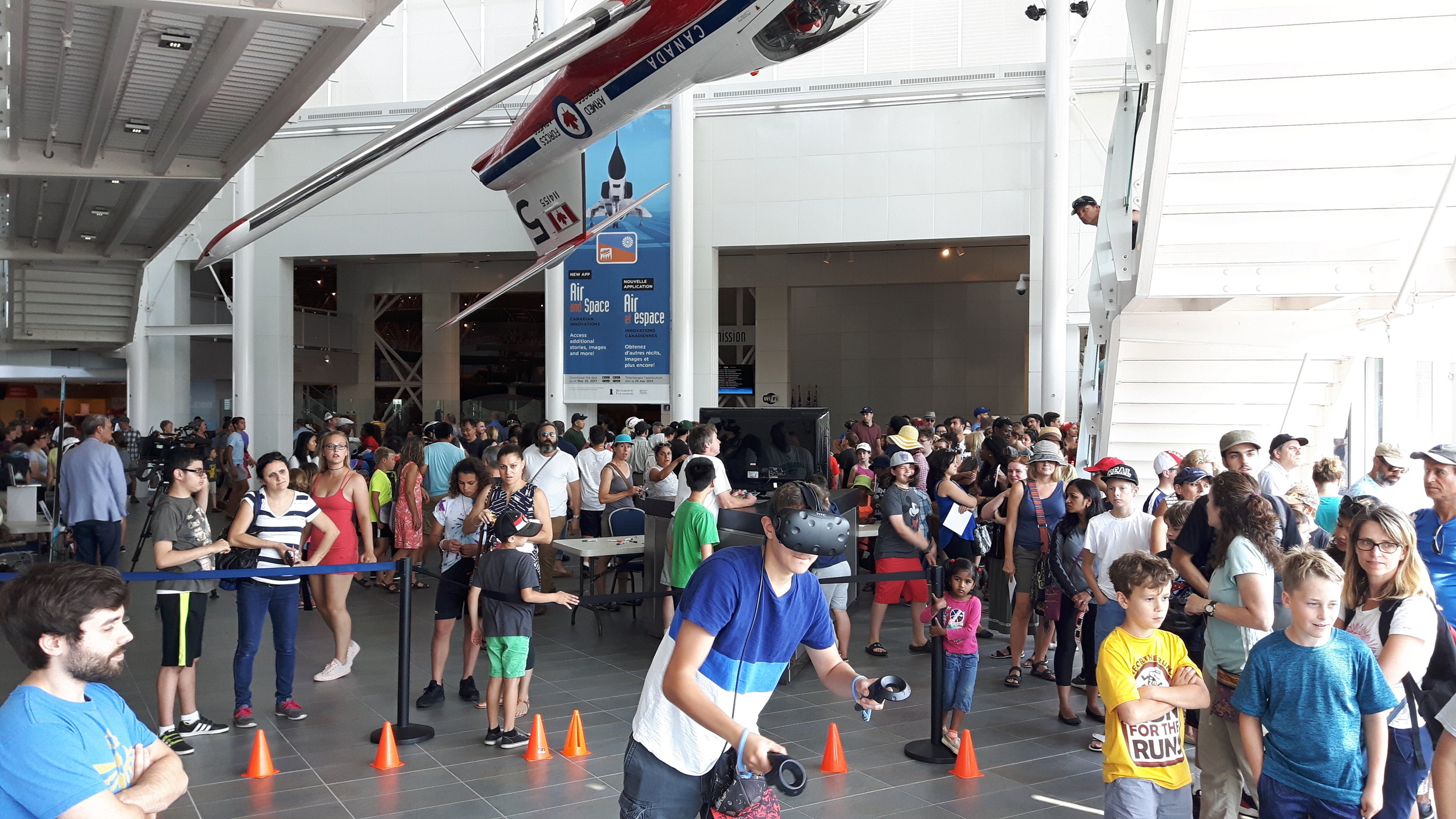 A large lineup of children and adults waiting and watching others try the demo during the solar eclipse event at the CASM.