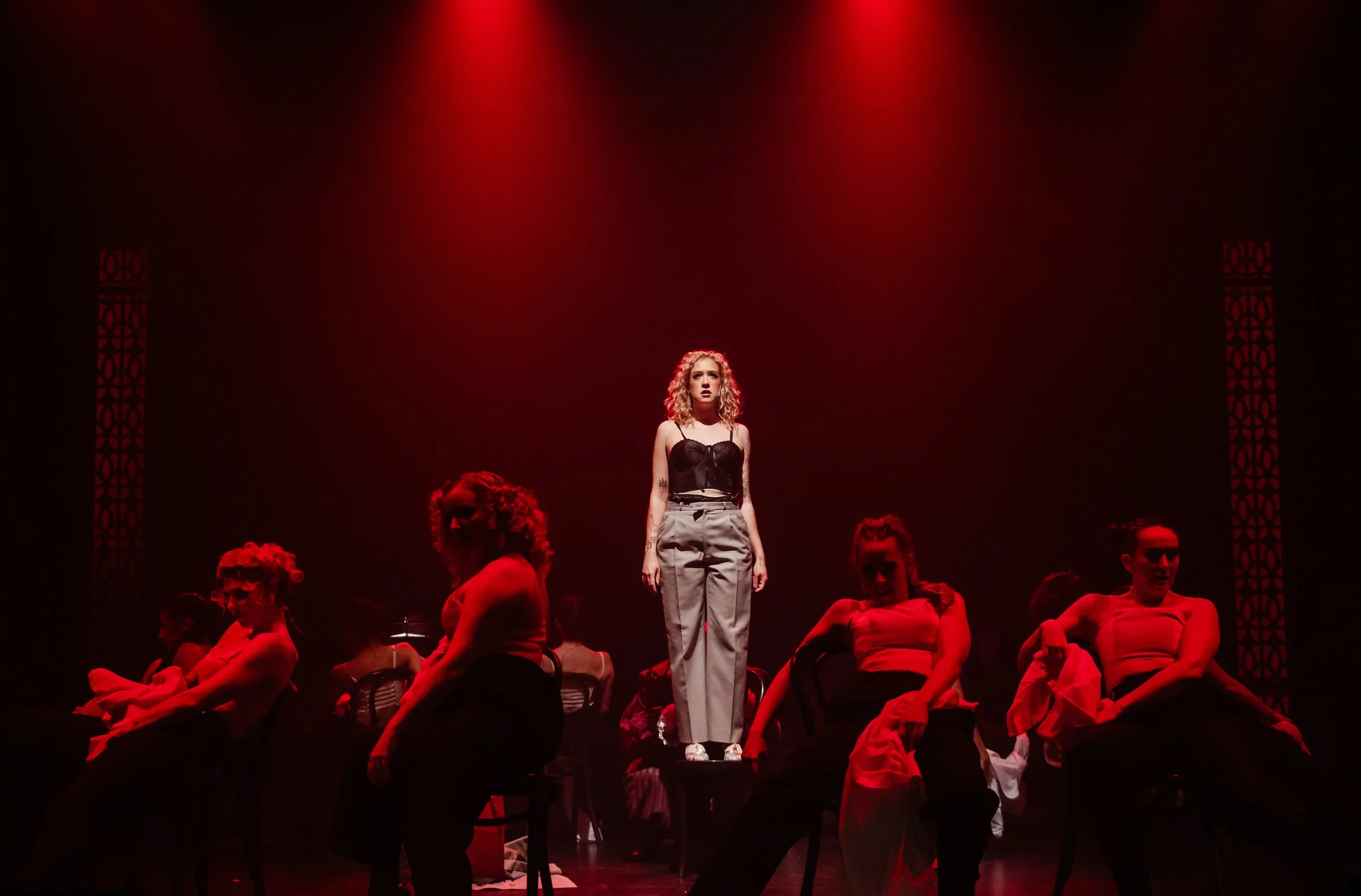 Immersive Cabaret theatre set design featuring a raised central stage, visible onstage band, multi-level platforms, and club-style audience seating surrounding the performance space, designed by Creativesphere.